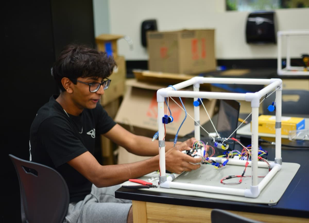 A BlueStamp student wiring the frame of their project